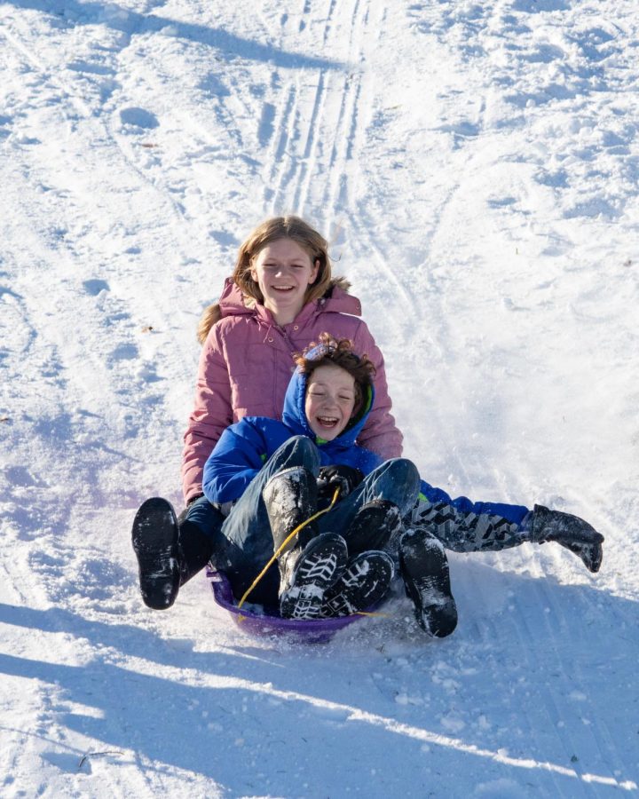 Two sledders laugh as they sled down a hill at the Banterra Center Feb. 4, 2022 in Carbondale, Ill. 