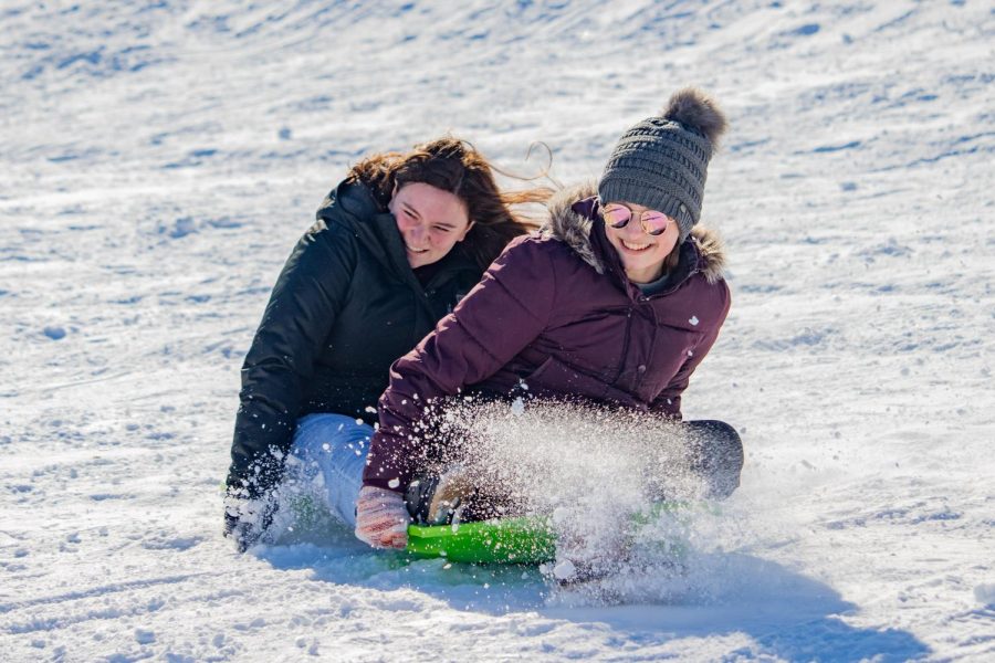 Two girls drift across the snow on a hill at the Banterra Center Feb. 4, 2022 in Carbondale, Ill. 