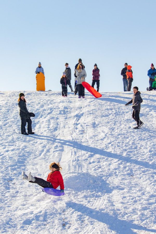 Sledders watch as a girl flies over a snow ramp on a hill at the Banterra Center Feb. 4, 2022 in Carbondale, Ill. 