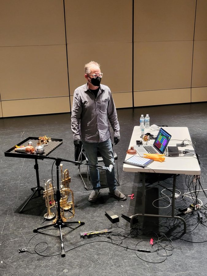 Jeff Kaiser stands with his “instrument,” a collection of trumpets, bells, balloons, a rubber chicken and assorted technology. 
