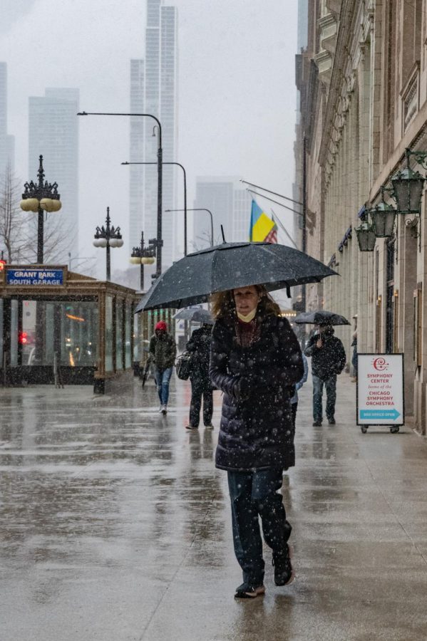 A woman walks through the rainy streets of Chicago March 18, 2022 in Chicago, Ill. 