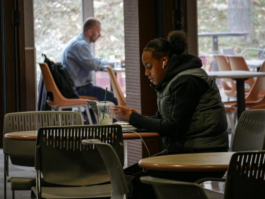 A student checks her phone while working on homework at the SIU  Student Center March 28, 2022 in Carbondale, Ill. 