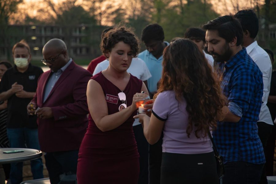 Saluki Cares Director/Confidential Advisor Amanda Hesunga lights candles for students and community members mourning the loss of SIU graduate students Vamshi Krishna Pechetty and Pavan Swarna April 22, 2022 at Becker Pavilion in Carbondale, Ill. 