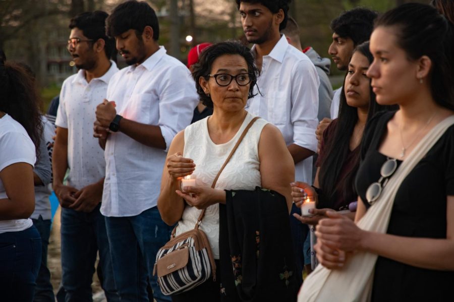 Community members protect their candles from the wind at the vigil for SIU graduate students Vamshi Krishna Pechetty and Pavan Swarna April 22, 2022 at Becker Pavilion in Carbondale, Ill. 