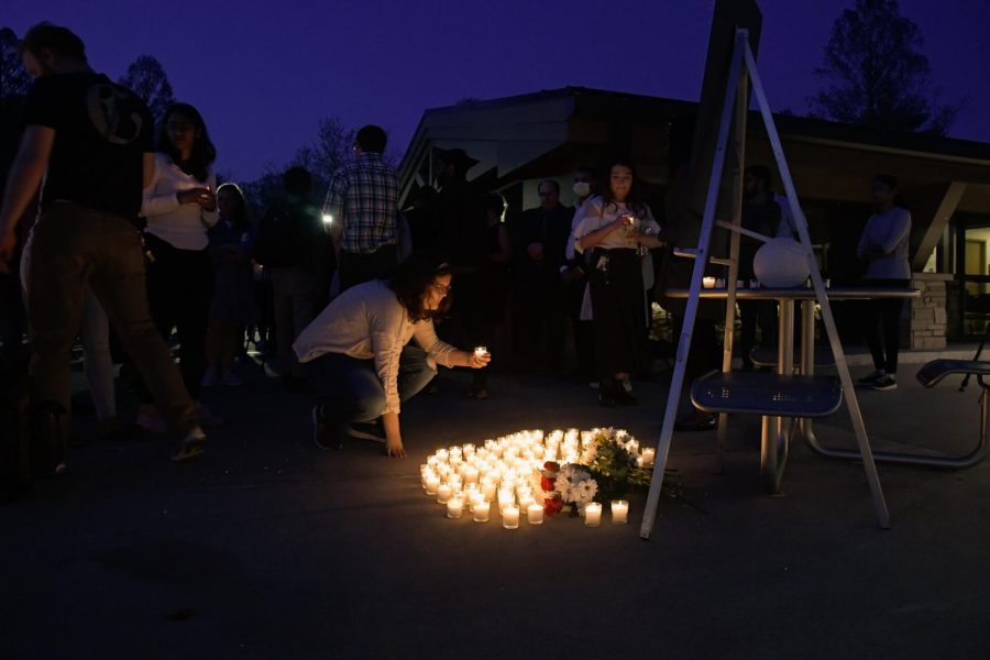 A girl lays down a candle for the SIU graduate students, Vamshi Krishna Pechetty and Pavan Swarna, who passed away in a car accident April 22, 2022 at Becker Pavilion in Carbondale, Ill. 