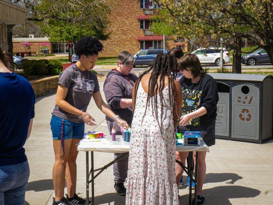 Resident assistant Aliyl McKinzie and other Thomspon Pointe Residents tie-dye shirts on Sunday April 10, 2022 in Carbondale, Ill. 
