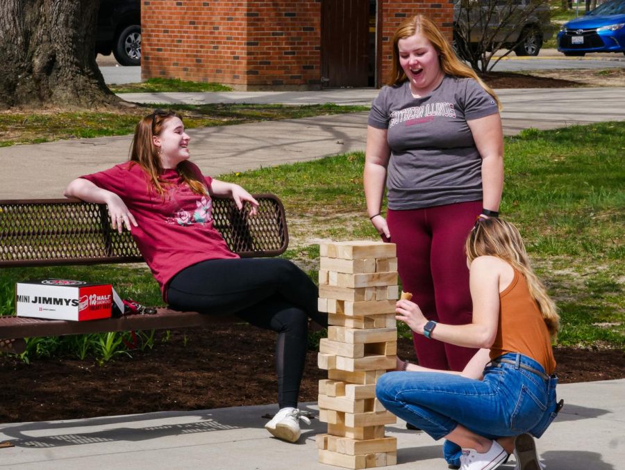 Resident Assistant Carson Doty and other Thompson Pointe reisdents play Jenga to de-stress before finals on Sunday April 10, 2022 in Carbondale, Ill. 