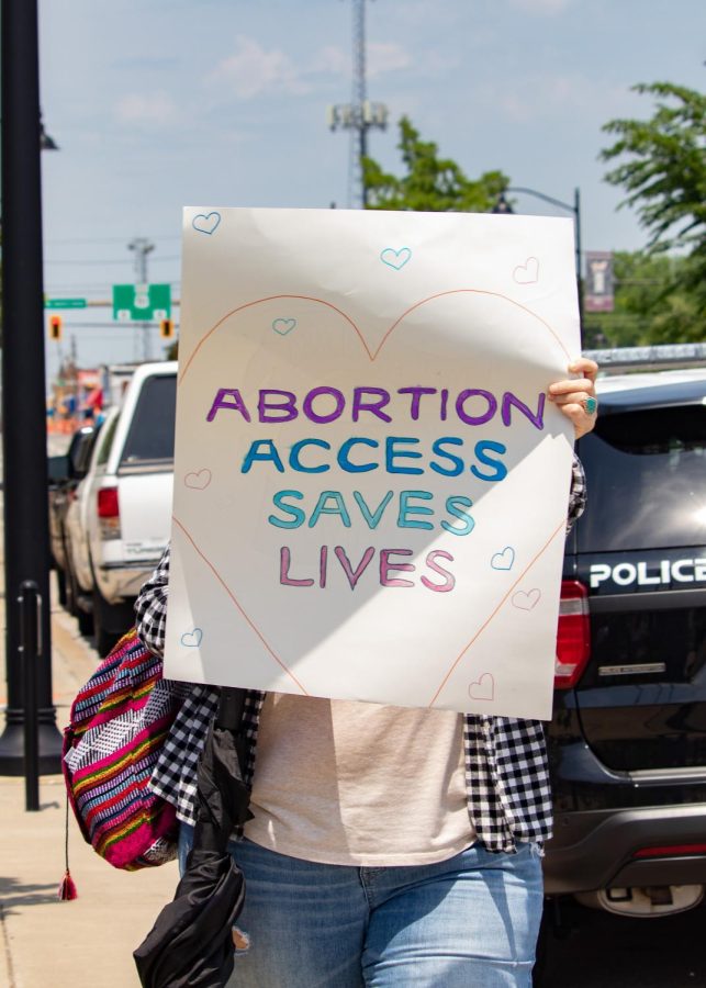 A woman holds a sign that says, Abortion Access Saves Lives during the Bans Off Our Bodies March May 14, 2022 in Carbondale, Ill. 