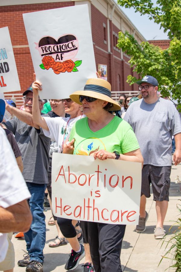 Community members and activists hold signs during the Bans Off Our Bodies March May 14, 2022 in Carbondale, Ill. 