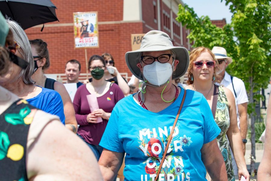 A woman marches in the Bans Off Our Bodies Protest with a shirt that says, Mind Your Own Uterus, May 14, 2022 in Carbondale, Ill. 
