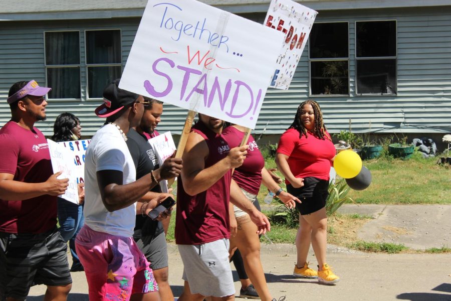 A participant holds a sign reading Together...We STAND! during the Juneteenth parade hosted by the African American Museum of Southern Illinois June 18, 2022 in Carbondale, Ill. 
