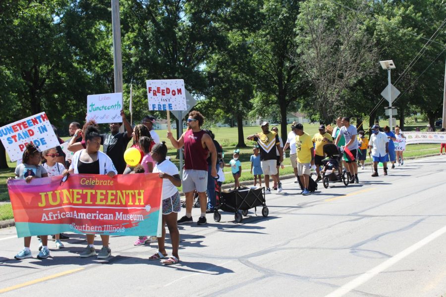 Participants hold a sign to celebrate Juneteenth during the Juneteenth parade hosted by the African American Museum of Southern Illinois June 18, 2022 in Carbondale, Ill. 