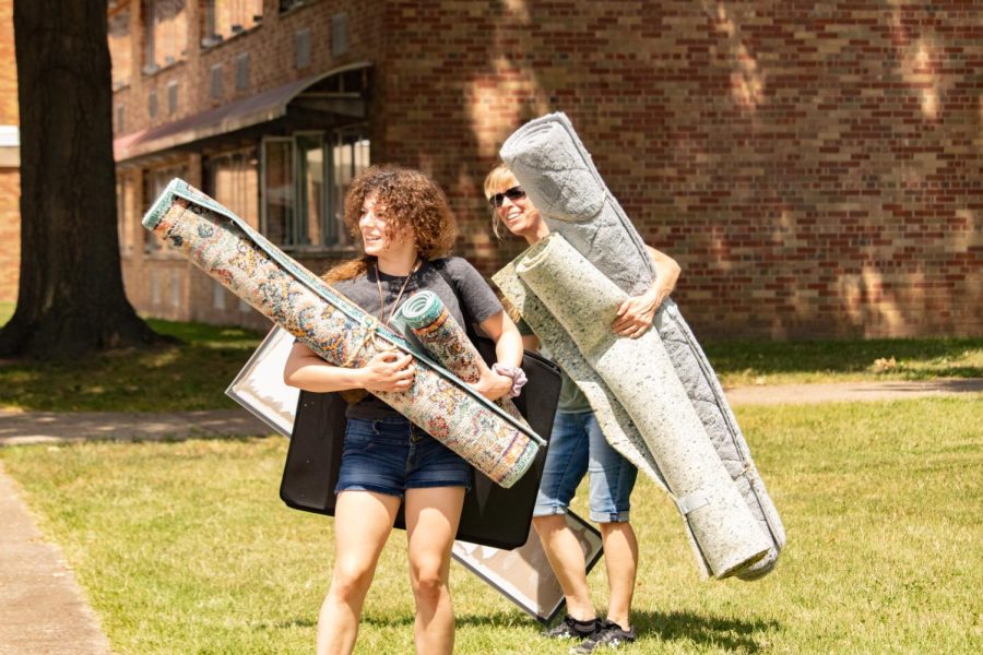 Two women carry rugs into the dorms Aug. 19, 2022 in Carbondale, Ill. 