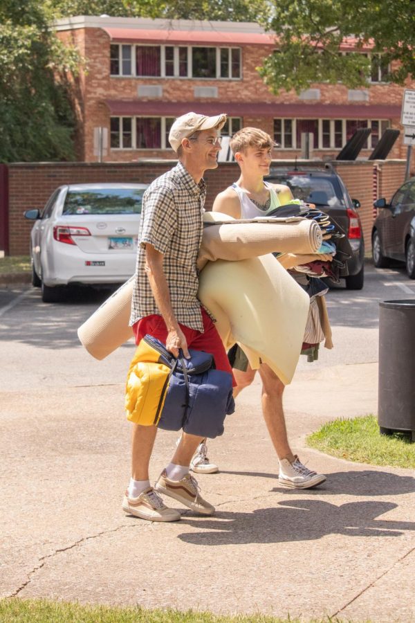 Two men carry clothes and bedding into the dorms during SIU move-in Aug. 19, 2022 in Carbondale, Ill. 