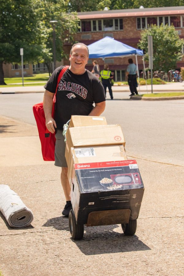 A man rolls dorm supplies into university housing during SIU move-in Aug. 19, 2022 in Carbondale, Ill. 