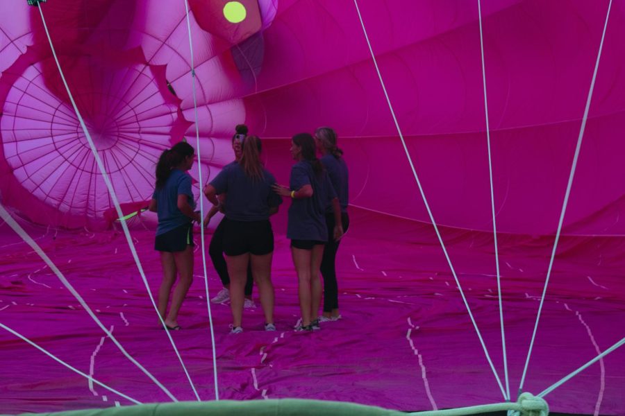 A group of girls stand inside the envelope of a hot air balloon as it rises Aug. 20, 2022 in Centralia, Ill. 