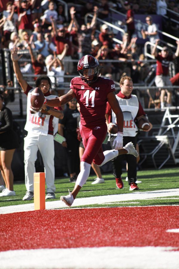 Avante Cox (11) holds out the ball as he crosses into the endzone, scoring a touchdown helping the Salukis take the victory over North Dakota during family weekend Sept. 24, 2022 at Saluki Stadium in Carbondale Ill.