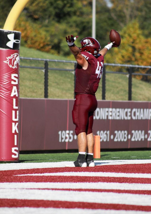 Jacob Garrett (43) stands in the endzone holding his arms out to the crowd celebrating his touchdown against the North Dakota Fighting Hawks for family weekend Sept. 24, 2022 at Saluki Stadium in Carbondale Ill.