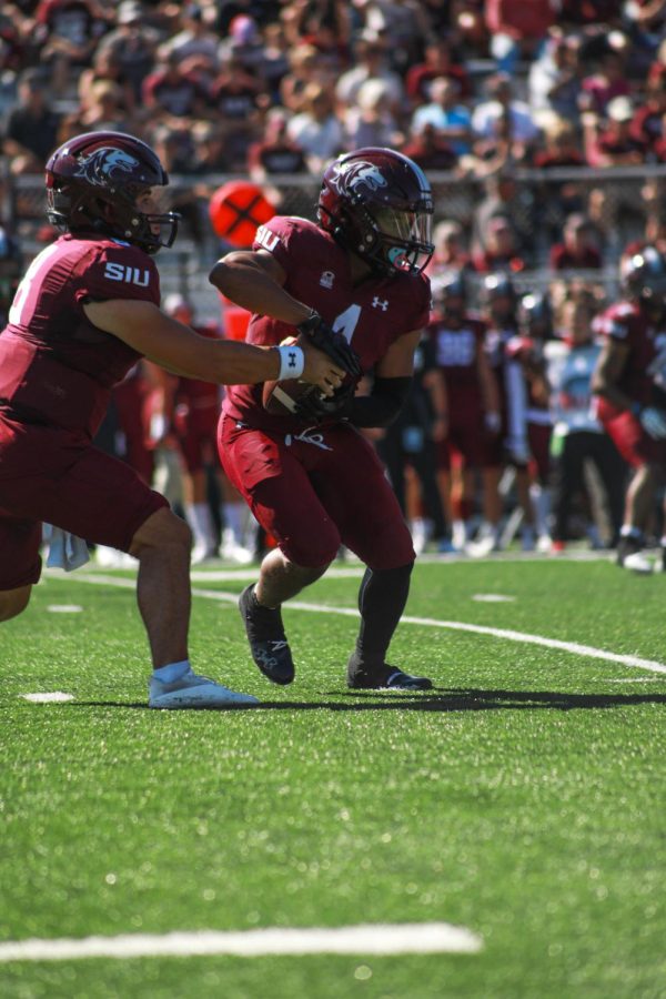 Quarterback Nic Baker (8) passes the ball to Running Back Romeir Elliot (1) during the family weekend home game Sept. 24, 2022 at Saluki Stadium in Carbondale, Ill.