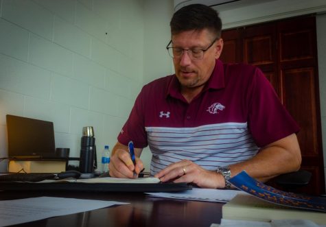 SIU athletic director Tim Leonard writes in a notebook Sept. 7, 2022 at Lingle Hall in Carbondale, Illinois.