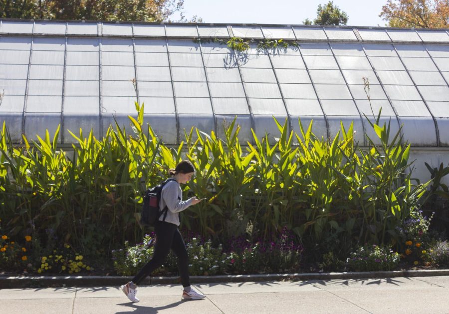 An SIU student walks past the SIU greenhouse Oct. 20, 2022 at SIU in Carbondale, Ill.
