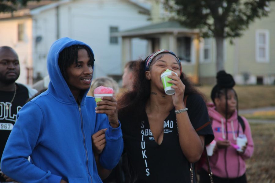 Andrianna Robinson eats snow cone with her partner DeAngelo Donaldson Oct. 13, 2022 at this year’s block party on campus in Carbondale, Ill. “They have super fun things to do this year,” Robinson said.