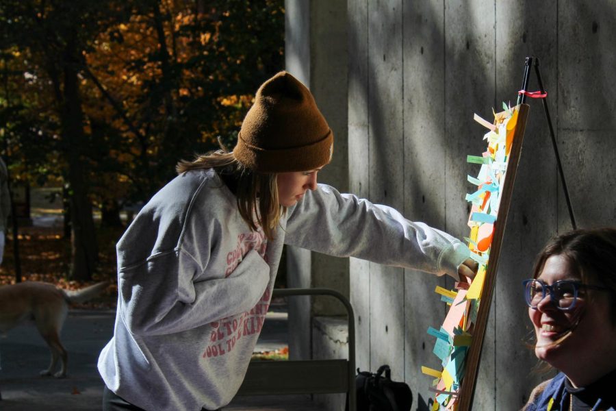Ashley Ege examines kindness board Oct. 17, 2022 outside Faner Breezeway in Carbondale, Ill. “Everyone has a silent battle we know nothing about, it’s the least we can do to be kind to others and recognize we are all human,” Ege said. 
