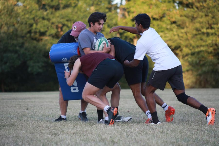 David Gomes reaches to grab the ball from Will Wise while running an offload drill that worked on ball exchange during practice on Sept. 27, 2022 in Carbondale, Ill.