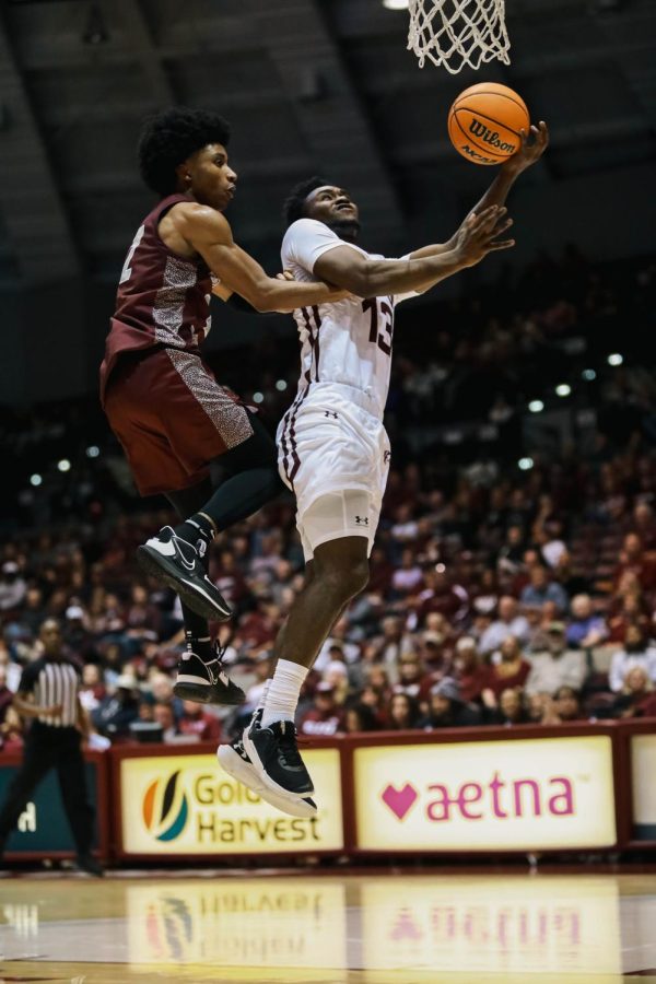 Jawaun Newton (13) leaps into the air for a layup as D.J. Smith (2) attempts to block during the season home opener against the Little Rock Trojans Nov. 7, 2022 at the Banterra Center in Carbondale, Ill.