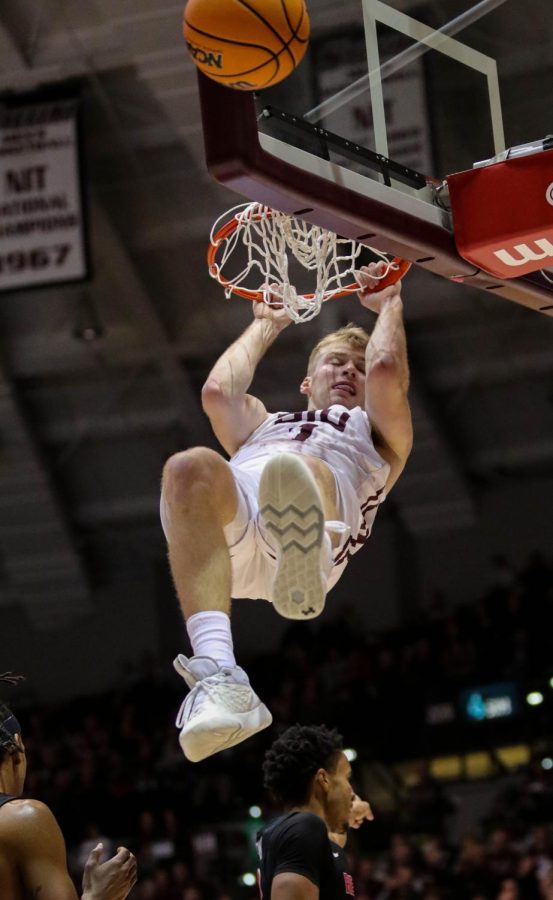 Marcus Domask (1)  hangs from the basket after dunking the ball on the opposing Redbirds to help the Salukis trail past Illinois State in the second half Jan. 14, 2023 at the Banterra Center in Carbondale, Ill. 