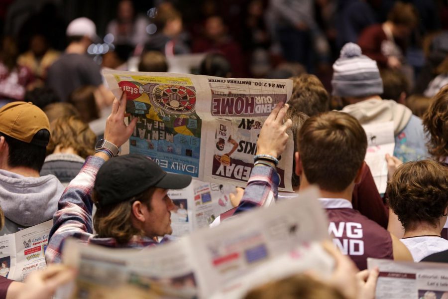 Turning their backs to the court, members of the Dawg Pound hold up copies of The Daily Egyptian and pretend to read while the starting five of the Murray State Racers are announced to the court Jan. 25, 2022 at Banterra Center in Carbondale, Ill.