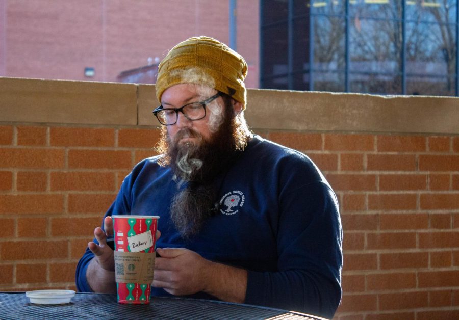 Zachary Current, a fermentation science major, enjoys his drink outside of the student center. Jan. 23, 2023 at the Student center at SIU in Carbondale, Ill. “I shop more at thrift shops.” Current said.