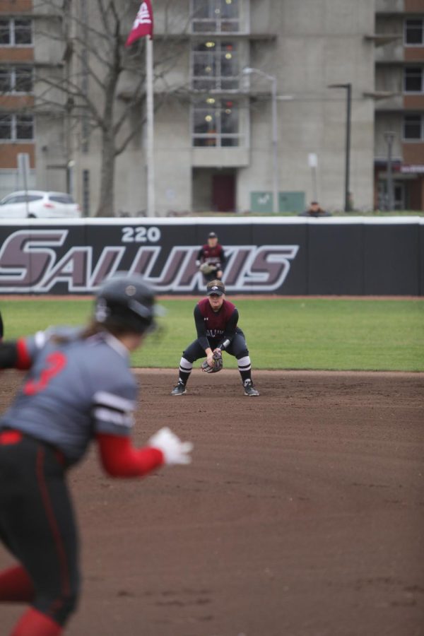 Erin Lee (24) waits for the next play as Emma Neuman (3) of Southern Illinois University Edwardsville is sent to first on a walk Feb. 26, 2023 at Charlotte West Stadium in Carbondale, Ill.