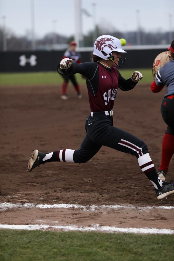 Emma Austin (21) crosses first base just before the first baseman of Southern Illinois University Edwardsville makes the catch Feb. 26, 2023 at Charlotte West Stadium in Carbondale, Ill.