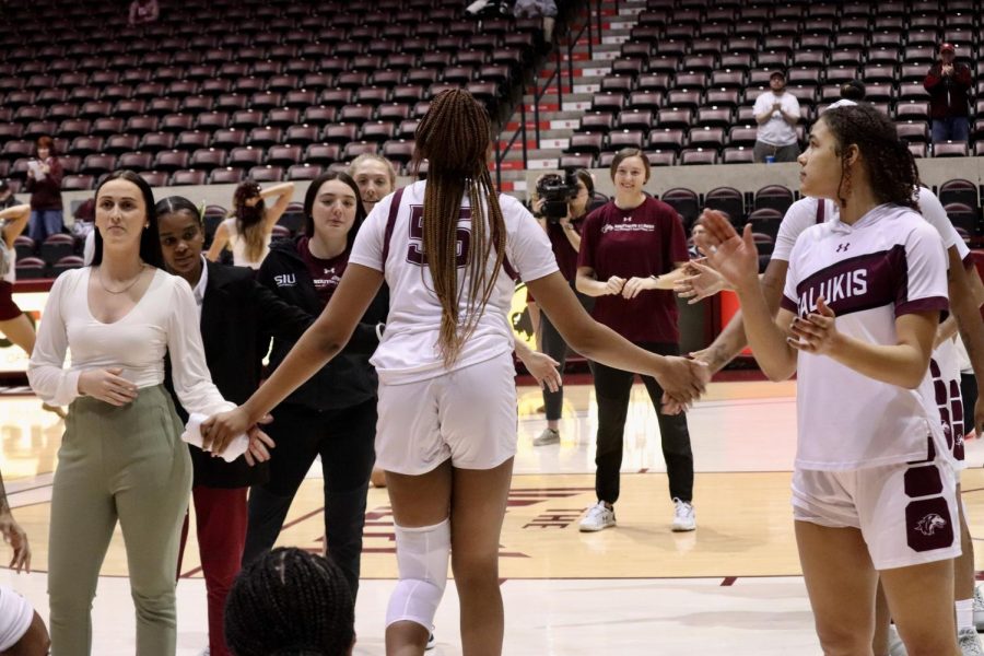 Promise Taylor (55) high fives her fellow Salukis as she enters the court Feb. 23, 2023 at the Banterra Center in Carbondale, Ill. 