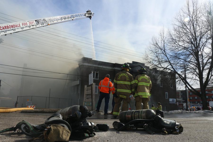 Firefighters and city workers watch as the Missionary Baptist Church fire is contained by the Carbondale and Murphysboro fire departments, Monday Feb. 6, 2023.