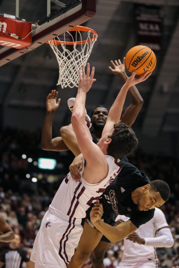 James Graham III (21) of Missouri State falls over Troy D’Amico (23) on the block attempt as D’Amico tosses the ball towards the basket Feb. 5, 2023 at Banterra Center in Carbondale, Ill.