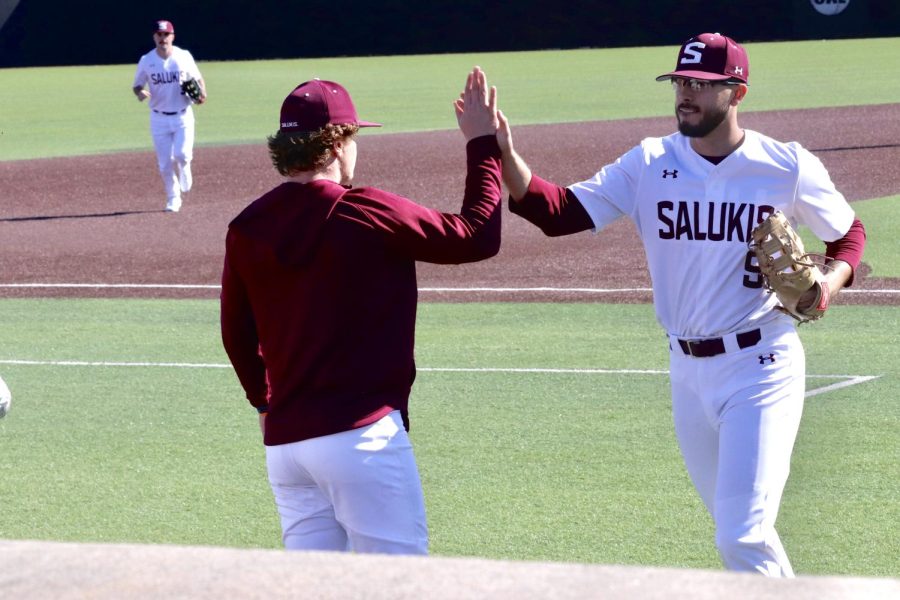 Ryan Rodriguez (9) gives a high-five after the Salukis end their defense run March 04, 2023 at the Itchy Jones Stadium in Carbondale, Ill.