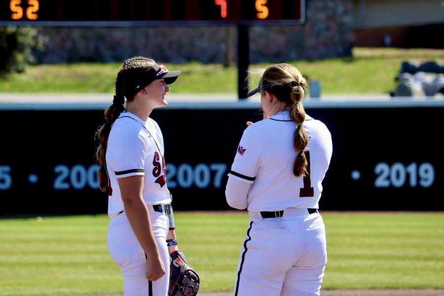 Rylie Hamilton (1) discusses strategy along with her teammate in the first game of the conference play against the Beacons of Valpo March 17, 2023 at the Charlotte West Stadium in Carbondale, Ill.