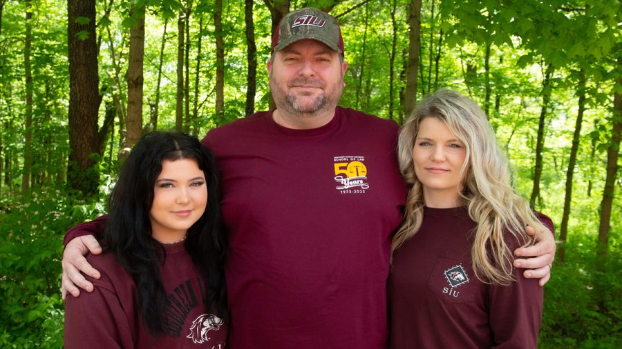 Continuing the mission: Ryan Taylor, center, with daughter, Abigail, left, and wife, Laura, are all SIU Carbondale students. Ryan Taylor will graduate from the SIU School of Law on May 12; while Abigail and Laura Taylor are both students in the Fashion Studies program. (Photo by Russell Bailey)
