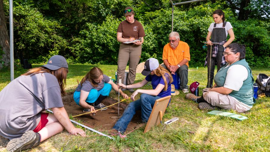 Led by Mark Wagner (orange shirt), an associate professor in anthropology, students in SIU Carbondale’s Archaeology Field School work on excavating an area an American fort once stood at Fort Kaskaskia in Randolph County. (Photo by Carson VanBuskirk)