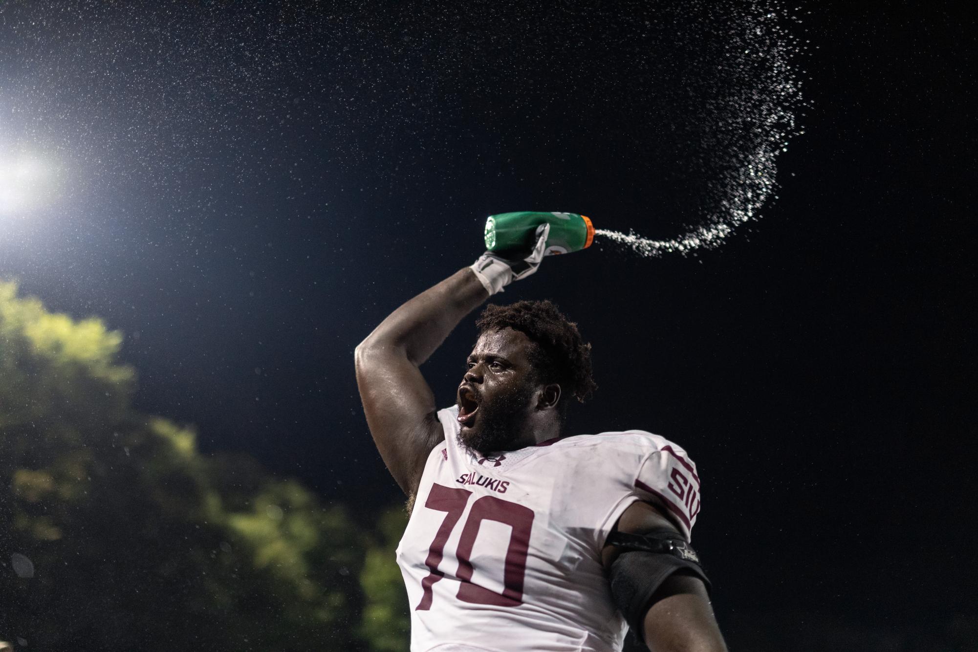 Abdou Toure (70) sprays water from the team gatorade bottles at the Dawg Pound in celebration as the Salukis pull ahead of the SEMO Redhawks by one point with a touchdown in the last few seconds of the fourth Sept. 16, 2023 at Houck Stadium in Cape Girardeau, Missouri.
