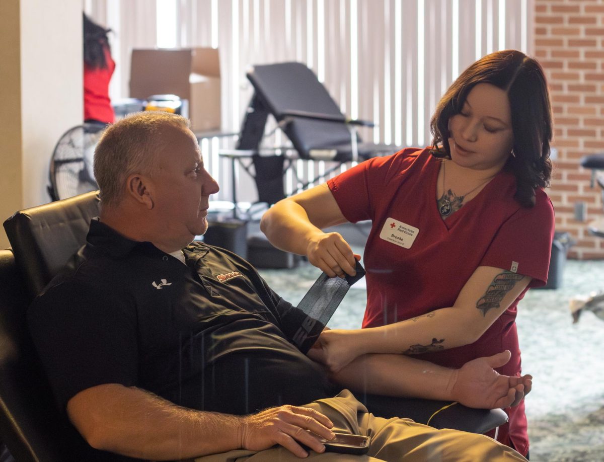 Brooke Johnson helps Jim Hunsaker donate blood at the Homecoming Blood Drive in the Cambira Room at the Student Center in SIU Carbondale, Illinois October 4, 2023. 