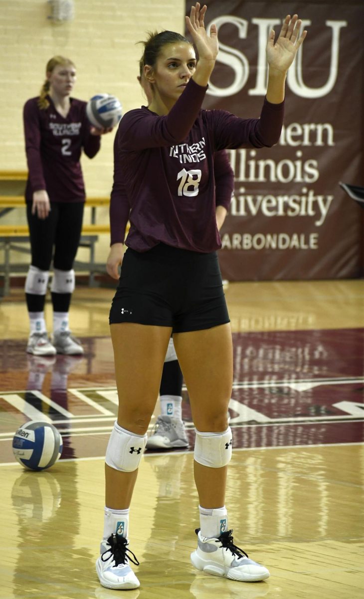SIU Women’s Volleyball senior Tatum Tornatta (18) practices her blocks as a teammate warms up her serves before a match against UIC at Davies Gym in Carbondale, IL on Saturday Oct. 21, 2023.