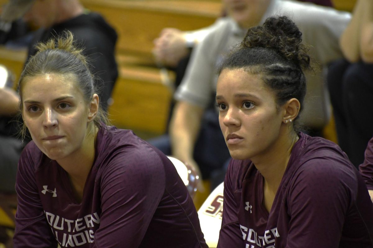 SIU Women’s Volleyball seniors Tatum Tornatta (18) and Nataly Garcia (17) listen as Head Coach Ed Allen addresses the team after winning the first set against UIC at Davies Gym in Carbondale, IL on Saturday Oct. 21, 2023.