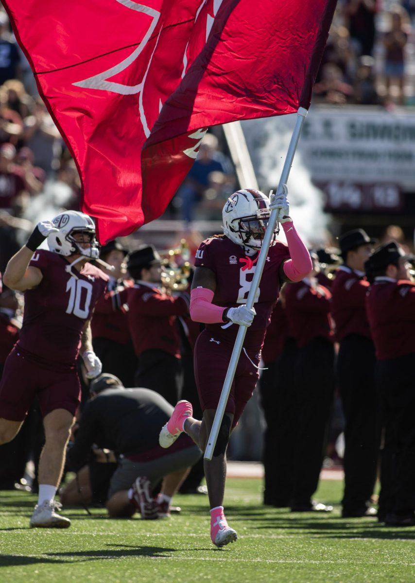 Dune Smith (8) leads the Salukis on to the field at the start of the game for the homecoming matchup against South Dakota State Oct. 21, 2023 at Saluki Stadium in Carbondale, Illinois. 