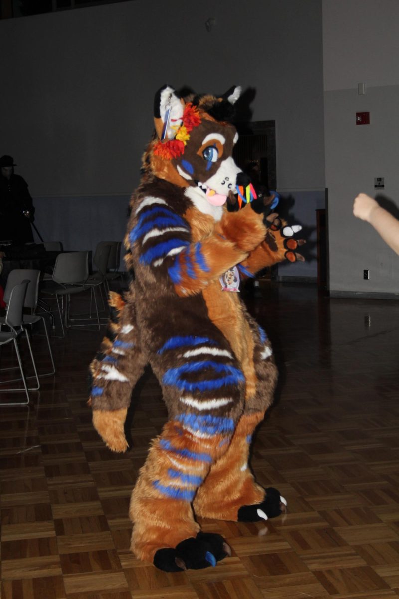 A Saluki Furry Society member dances with a group of friends during the Spooky Saluki Costume Party in the Student Center Ballroon in Carbondale, Illinois on October 21, 2023.