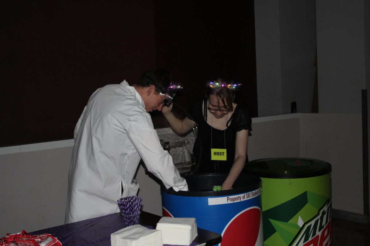 Concession workers, Courtney East (right) and Logan Smith (left) rearrange sodas duringthe Spooky Saluki Costume Party in the Student Center Ballroom on October 21, 2023 in Carbondale, Illinois.