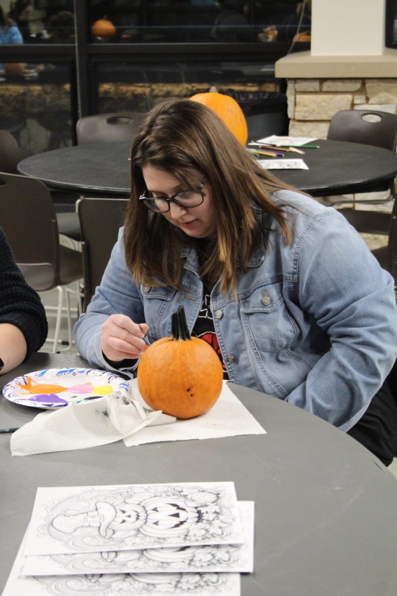 Rebekka McSpadden paints a pumpkin Oct. 24, 2023 at Becker Pavilion in Carbondale, Illinois.