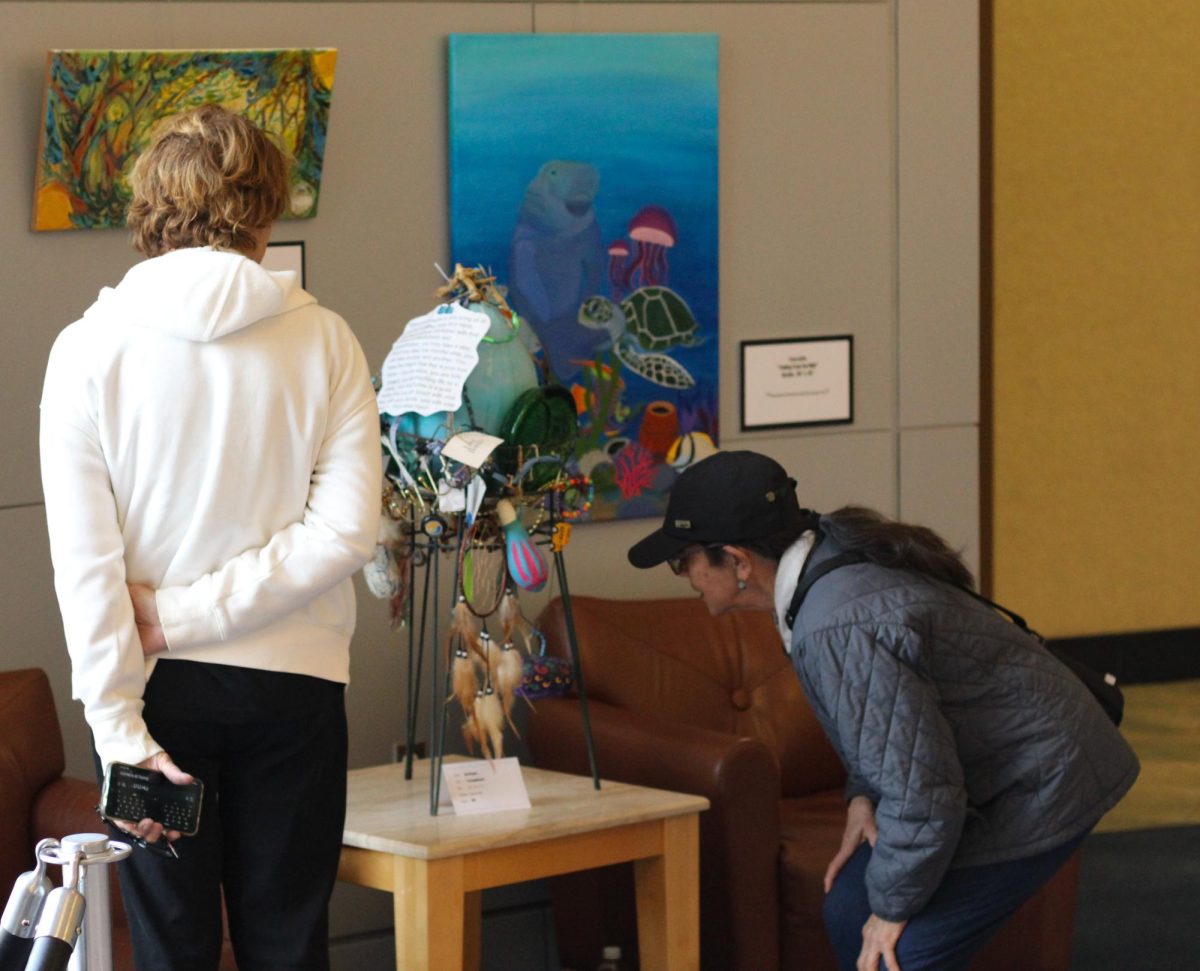 Jan Treece (left) and Rachel Young (right) visit the Wild Things Art Show in the Rotunda Nov. 3, 2023 at Morris Library in Carbondale, Illinois.